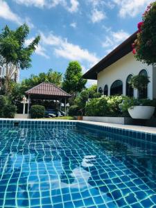 een zwembad voor een huis bij Summer House,shared pool, private bathroom and kitchen in Ban Phlu Yai