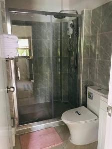 een badkamer met een douche en een toilet bij Summer House,shared pool, private bathroom and kitchen in Ban Phlu Yai