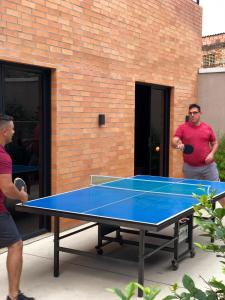 庫庫塔的住宿－Hotel Macaw Cúcuta，两个人站在乒乓球桌旁