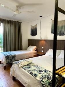 Habitación de hotel con 2 camas y ventana en Hotel Macaw Cúcuta en Cúcuta