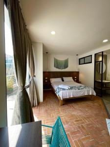 um quarto com uma cama e uma grande janela em Hotel Macaw Cúcuta em Cúcuta
