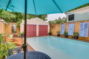 a swimming pool with an umbrella in a yard at Private Pool and Backyard Lavish New Orleans Haven! in New Orleans