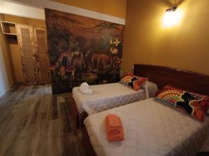 una camera con due letti e un dipinto sul muro di Appartamento Villa Matilde a Borgata Zarattini