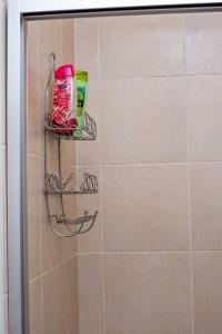 a bathroom with a shower with a shelf on the wall at Your home away from home in Lusaka