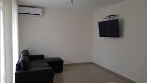 a living room with a couch and a tv on a wall at Habitación dentro de una casa en un condominio tipo Resort in Santa Cruz de la Sierra