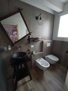 a bathroom with a sink and a mirror and a toilet at Appartamento Villa Matilde in Borgata Zarattini