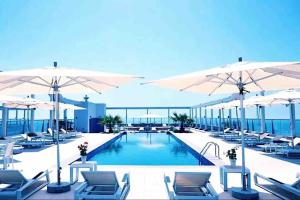 a swimming pool with chairs and umbrellas at Sunshine in Ras al Khaimah