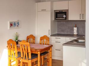 cocina con mesa de madera y 4 sillas en Apartment house Jann-Berghaus, Norderney, en Norderney