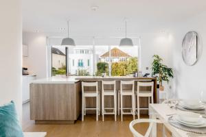 a kitchen with white walls and a large window at Windward in Poole