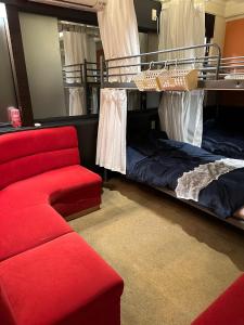 a living room with a red couch and bunk beds at Guest House Tosa Otesujihana Dormitory women only- Vacation STAY 14354 in Kochi