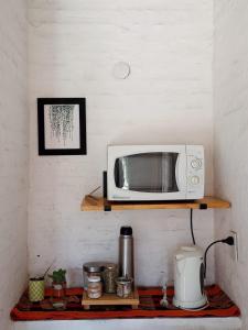 un microondas sentado en un estante en una cocina en Quinta El Cholito en Luján
