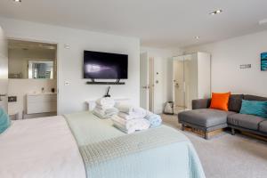 a bedroom with a bed and a couch and a tv at Windward in Poole