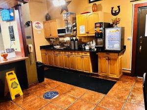 a kitchen with wooden cabinets and a counter top at Super 8 by Wyndham Dodge City in Dodge City