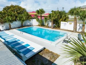 a large swimming pool with a white fence and palm trees at Bahama Breeze Suites in Panama City Beach