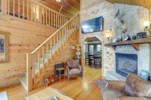 a living room with a staircase and a fireplace at Above and Beyond Pigeon Forge Cabin with Prime Views! in Pigeon Forge