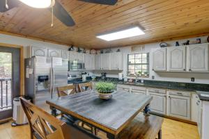 a kitchen with white cabinets and a table with a plant on it at Above and Beyond Pigeon Forge Cabin with Prime Views! in Pigeon Forge