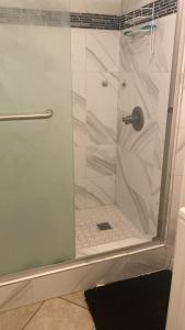 a shower with a glass door in a bathroom at Zen Home in Santa Ana