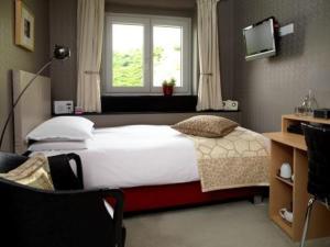a bedroom with a large bed and a window at B&B Rafters in Abingdon