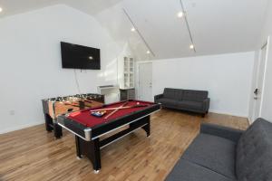 a living room with a pool table and a couch at Modern Home in New Haven in Hamden