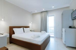 ein Schlafzimmer mit einem weißen Bett und einem großen Fenster in der Unterkunft Golfo Beach in Parga