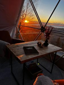 a table in front of a window with a sunset at Forbord Dome 