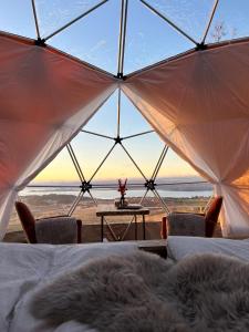 um quarto com vista para o oceano a partir de uma tenda em Forbord Dome 