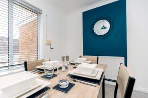 a dining room with a wooden table and a blue wall at Cherry House in Durham