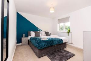 a bedroom with a bed with a blue accent wall at Cherry House in Durham