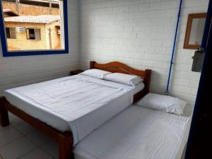 sypialnia z 2 łóżkami i oknem w obiekcie Chalé das Conchas w mieście Maragogi