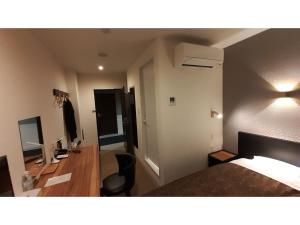 a hotel room with a bed and a desk with a computer at ＨＯＴＥＬ ＷＩＮ - Vacation STAY 72249v in Imari