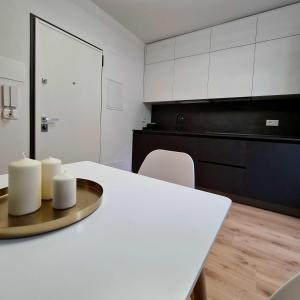 een keuken met een witte tafel en witte kasten bij Monolocale Mati - Holiday Home in Trento