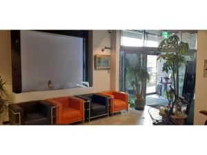 ein Wohnzimmer mit orangefarbenen Stühlen und einer Leinwand in der Unterkunft ＨＯＴＥＬ ＷＩＮ - Vacation STAY 72249v in Imari