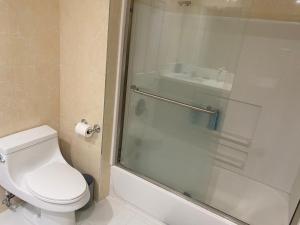 a bathroom with a toilet and a glass shower at Zen Home in Santa Ana +27 photos