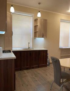 a kitchen with wooden cabinets and a table and a sink at Classic Hotel in Kharkiv