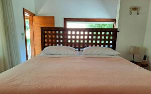 a bed with two pillows on it in a bedroom at Chalé Bromélia do Cerrado in Serra do Cipo