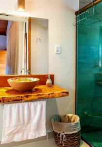 a bathroom with a sink and a glass shower at Chalé Bromélia do Cerrado in Serra do Cipo