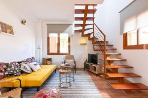sala de estar con sofá y escalera de caracol en Alcaudón HolidayFV, en Corralejo