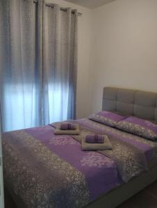 1 Schlafzimmer mit 2 Betten mit violetter Bettwäsche und Vorhängen in der Unterkunft Ada apartman in Banja Luka