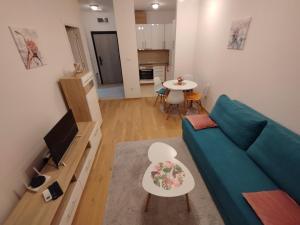 ein Wohnzimmer mit einem grünen Sofa und einem Tisch in der Unterkunft Ada apartman in Banja Luka