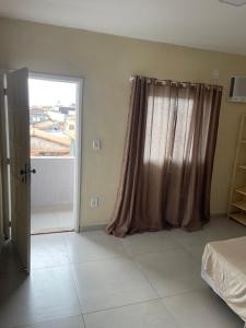 1 dormitorio con 1 cama y puerta corredera de cristal en Apartamento Formosa 155, en Cabo Frío