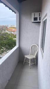 una silla sentada en un balcón con ventana en Apartamento Formosa 155, en Cabo Frío
