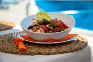 a bowl of food on a plate on a table at Apart Hotel Apolonia Palace in Sinemorets
