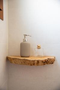 baño con dispensador de jabón en una estantería de madera en Alcaudón HolidayFV, en Corralejo