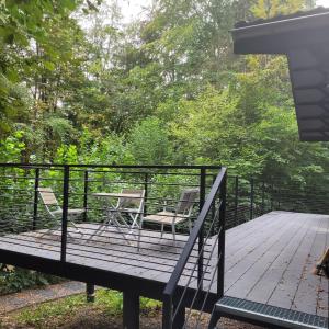 a deck with two chairs and a table at Gite Au chalet de Mélines 