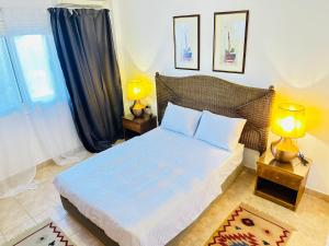 a bedroom with a bed with two lamps and a window at Casa Do Cairo-Sharm Alsheikh in Sharm El Sheikh