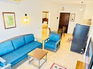 a living room with a blue couch and chairs at Casa Do Cairo-Sharm Alsheikh in Sharm El Sheikh