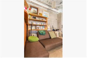 a living room with a couch and a book shelf at Little Okawood - Vacation STAY 83117v in Ōkawa