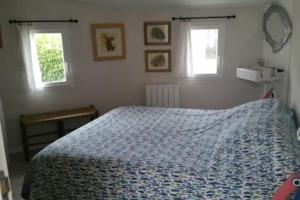 a bedroom with a blue bed with two windows at Bright house with garden - île de Ré in Saint-Clément-des-Baleines