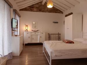 a bedroom with two beds and a dresser in it at Velanidies Traditional Ikarian House in Xilosírtis