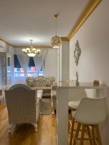 Il comprend une cuisine et un salon avec une table et des chaises. dans l'établissement Kruna apartman, à Banja Luka